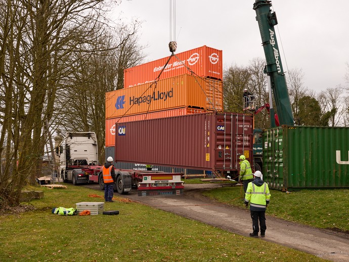 Kran hebt einen weiteren Container in die Höhe (vergrößerte Bildansicht wird geöffnet)