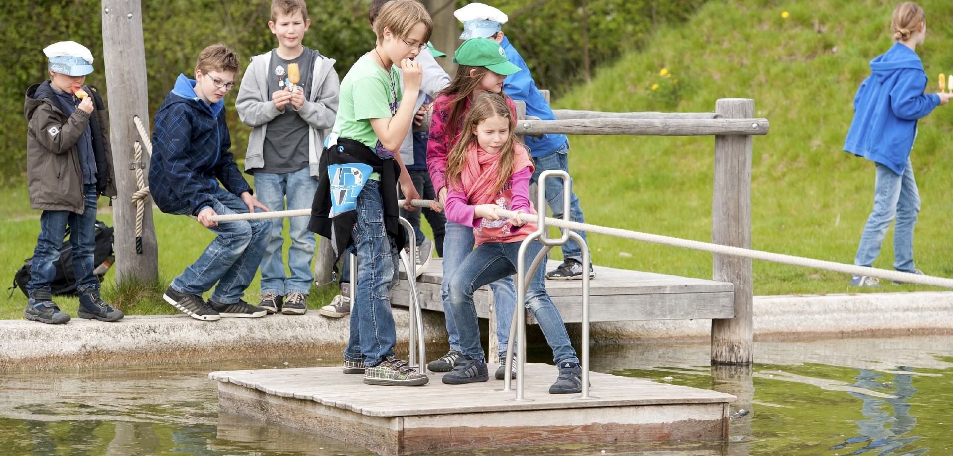 Kinder auf einem Floß auf dem Wasserspielplatz.