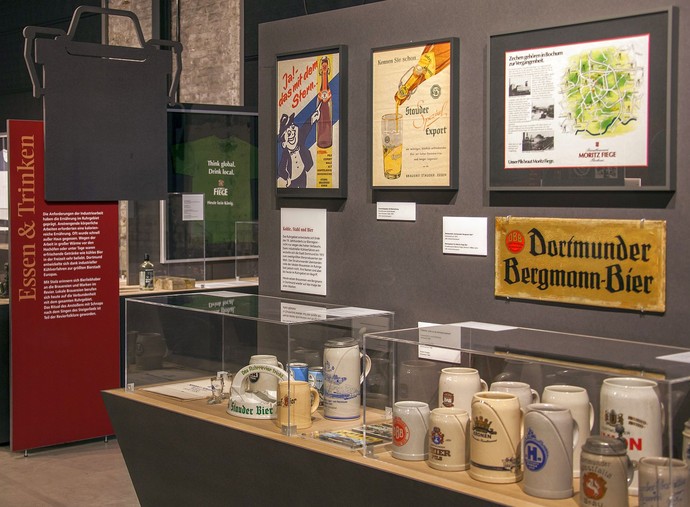 Blick in den Ausstellungsbereich "Essen und Trinken" mit verschiedenen Bierseideln und Werbeschilder von Brauereien.