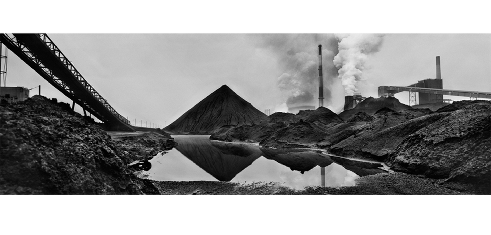 Schwarz weiß Fotografie von Joseph Koudelka. Zu sehen ist eine Kohlenhalde einer Zeche in Dunkerque im französischen Gebiet Nord-Pas de Calais.