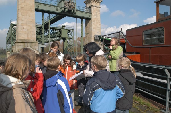 Kindergruppe vor einem Modell auf dem Museumsgelände.