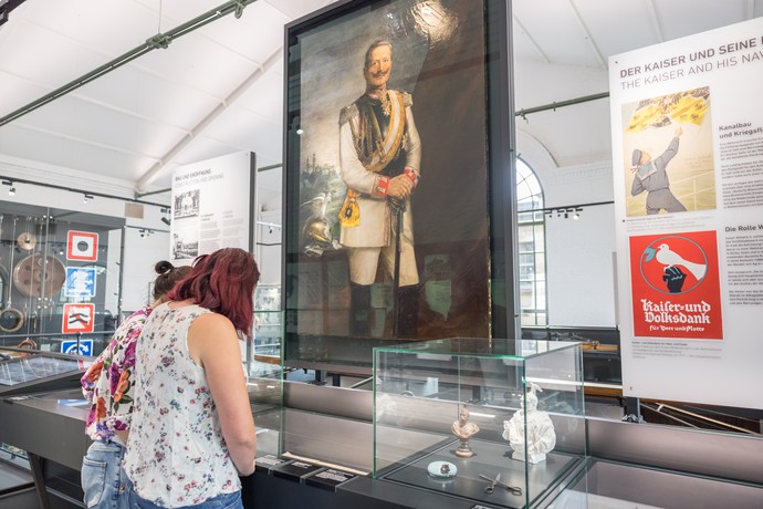 Blick in die Ausstellung mit einem lebensgroßen Porträt Kaiser Wilhelms.