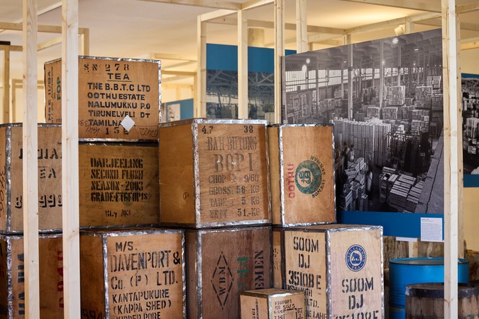 Blick in die Ausstellung mit Stapeln von Kisten, die für den Gütertransport der Vor-Container-Zeit stehen.