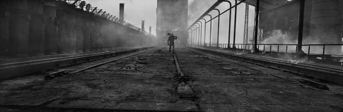 Schwarz-Weiß Fotografie, Arbeiter vor einer Industriekulisse. Josef Koudelka City of Dunkerque, Sollac, Region of Nord-Pas-de-Calais, France