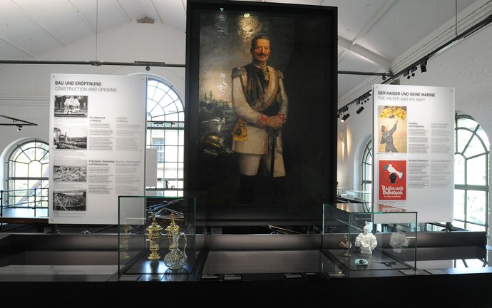Blick in die Ausstellung mit einem lebensgroßen Porträt Kaiser Wilhelms.