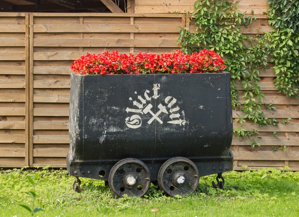 Bepflanzter Grubenwagen mit Glück auf Aufschrift.
