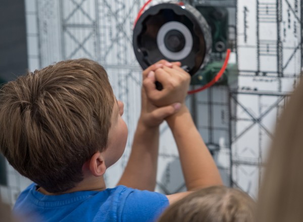 Jungen dreht an einer Experimentierstation im Schiffshebwerk